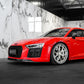 Red Audi car in a showroom with marble walls and large windows.