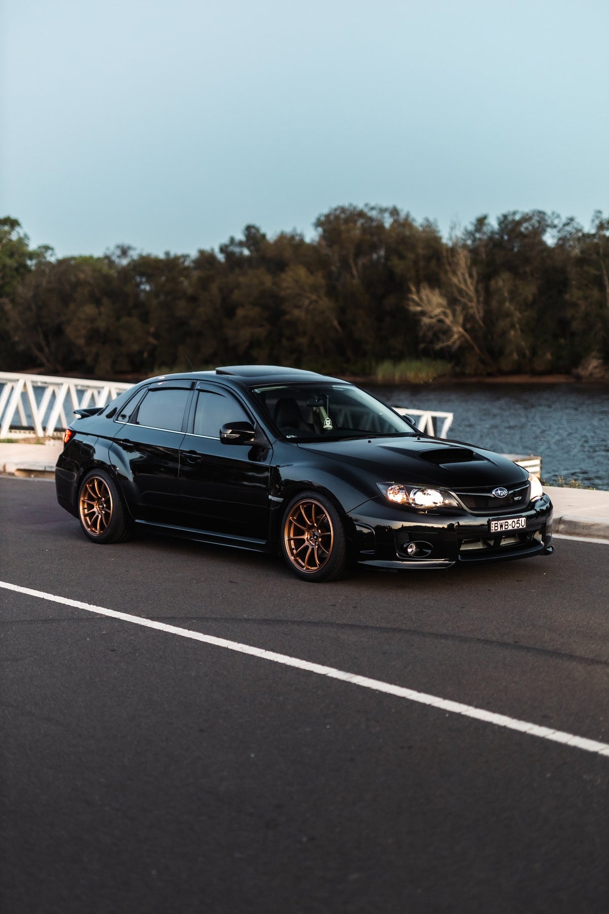 SWF01 forged wheels on a Subaru Impreza WRX, front three-quarter at sunset