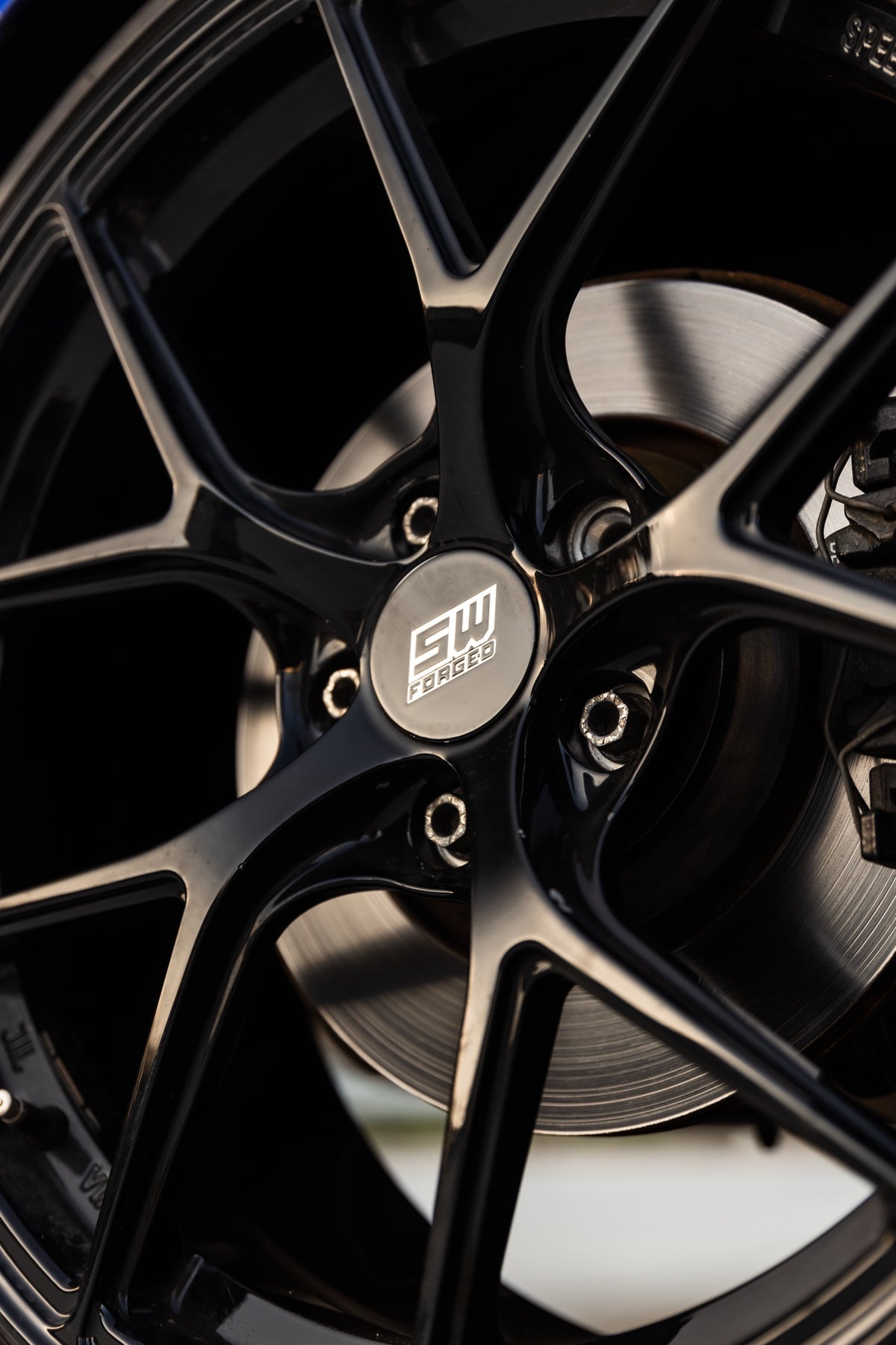 SWF02 forged wheels in Gloss Black on a blue Volkswagen Golf R Mk7, spoke and centre cap detail